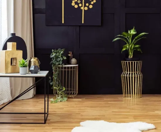 Modern living room with gold accents and plants.