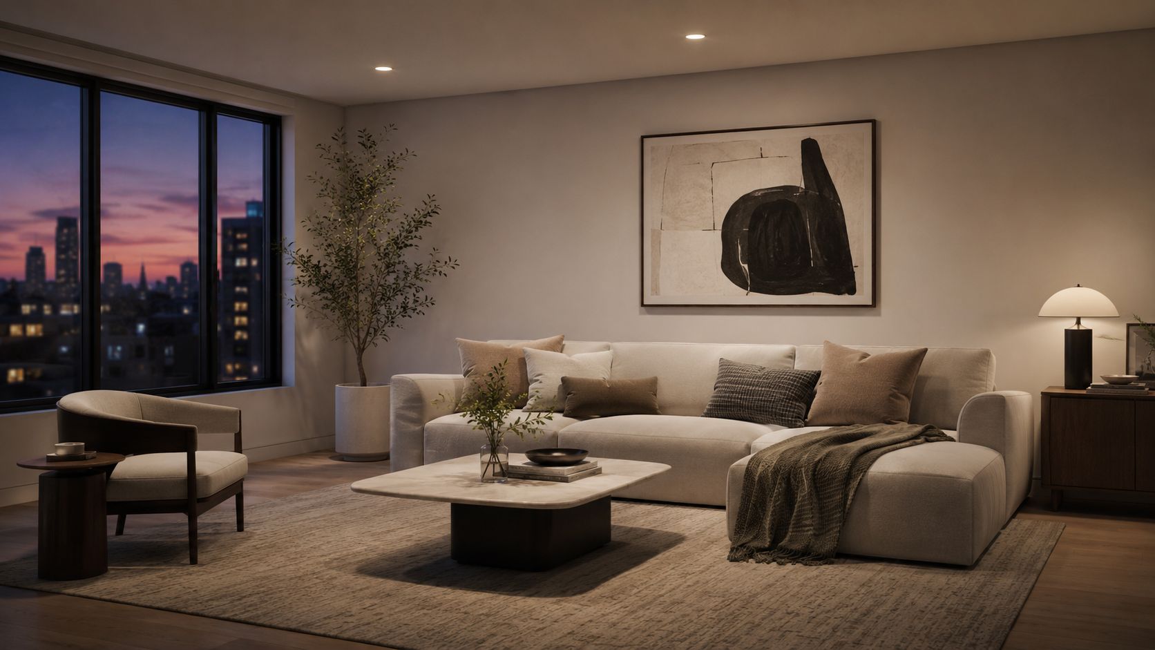 A modern living room with a neutral sofa, coffee table, and an abstract painting during sunset.